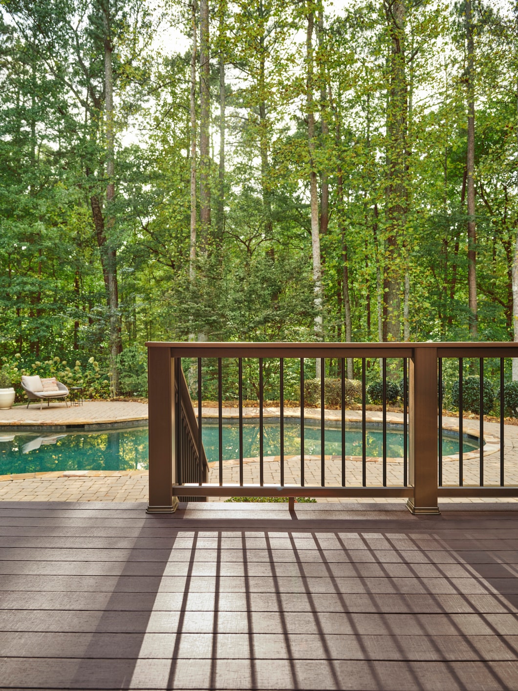 TimberTech Landmark American Walnut deck surrounded by lush greenery